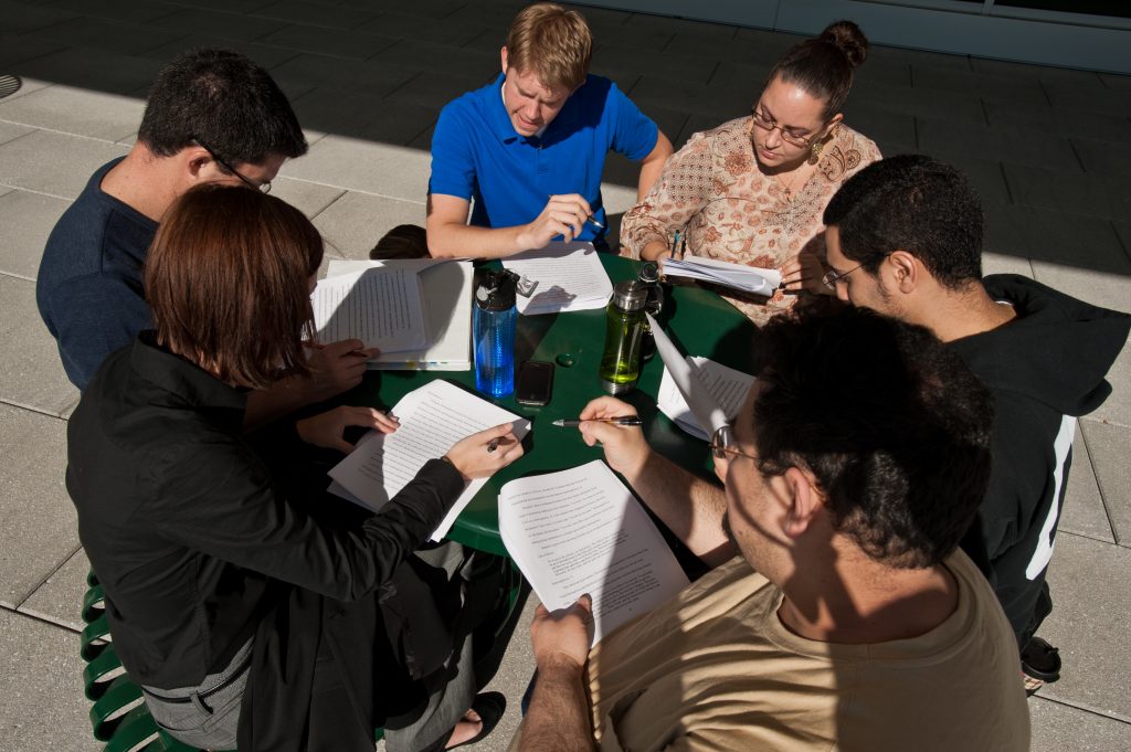 Students study at a table outside Founders Hall at Mason's Arlington Campus